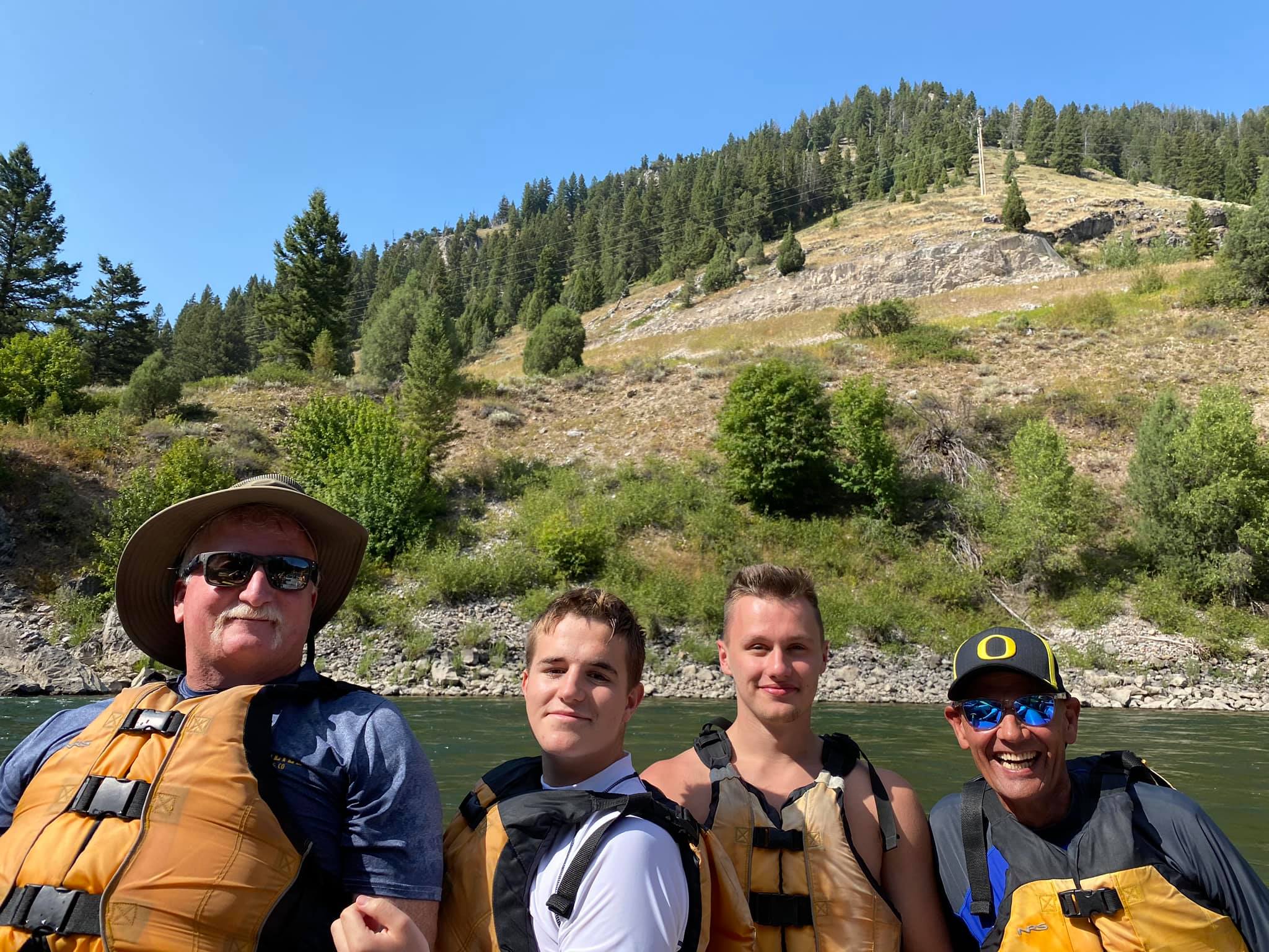 two fathers with two sons river rafting