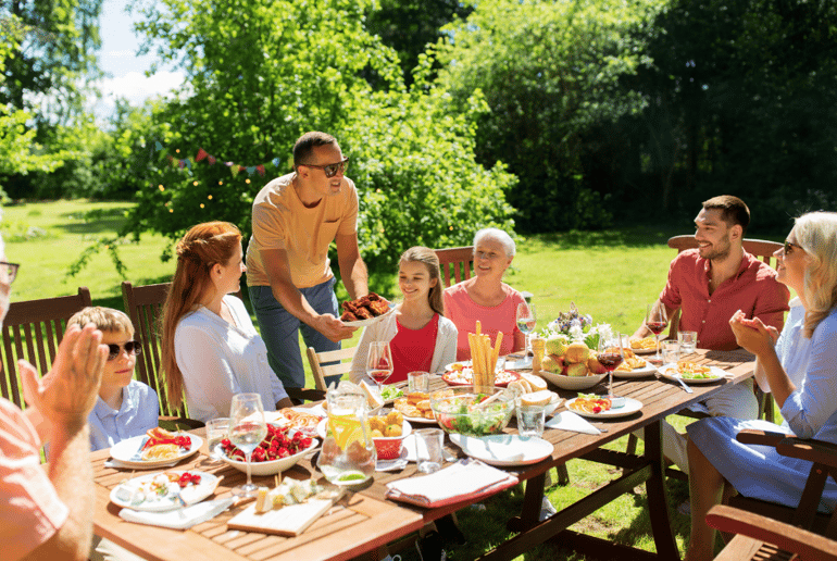 A family seated at an outdoor table enjoying food together