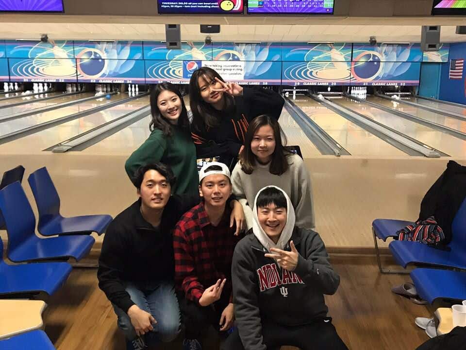 South Korean exchange students at a bowling alley posing in front of a lane