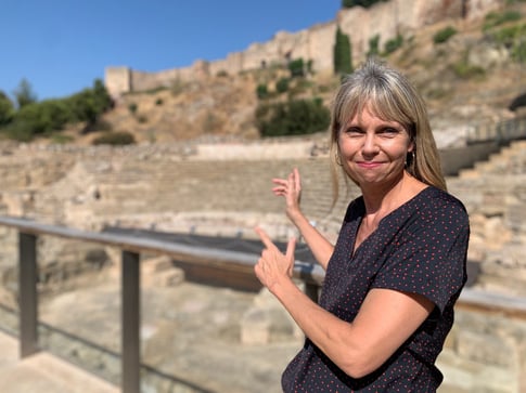 Brenda Padilla Ericksen pointing to Roman Ruins in Malaga (and the Alcazaba)