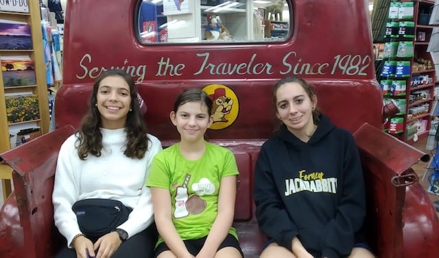 Spanish teenage girl with two american host sisters in the back of an antique truck