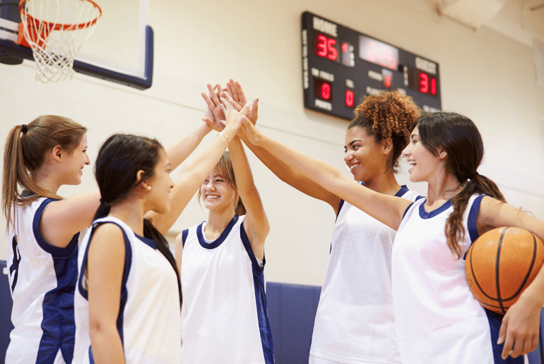 Group of girl basketball players high fiving each other
