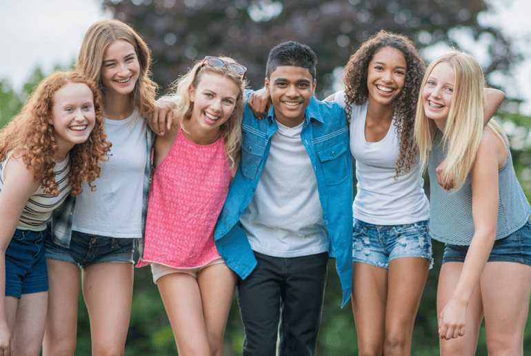 Group of teens smiling with their arms around each other
