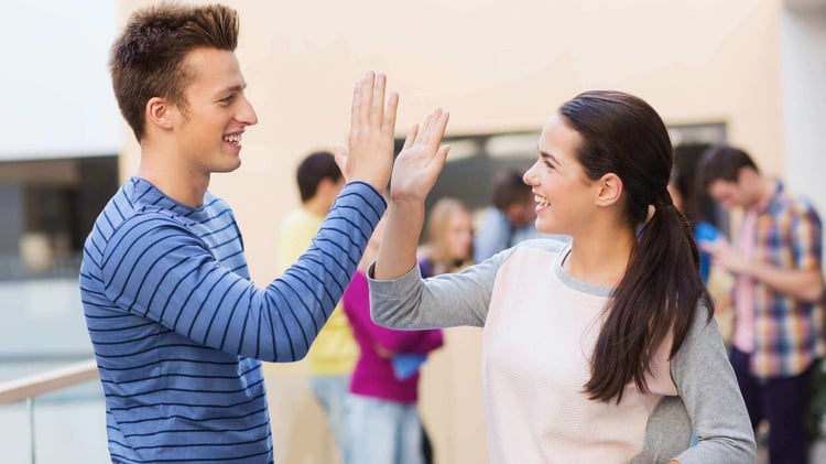 Teen boy and teen girl in a high five