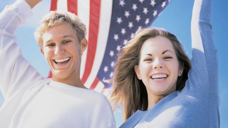 Teenage boy and girl in front of an American flag