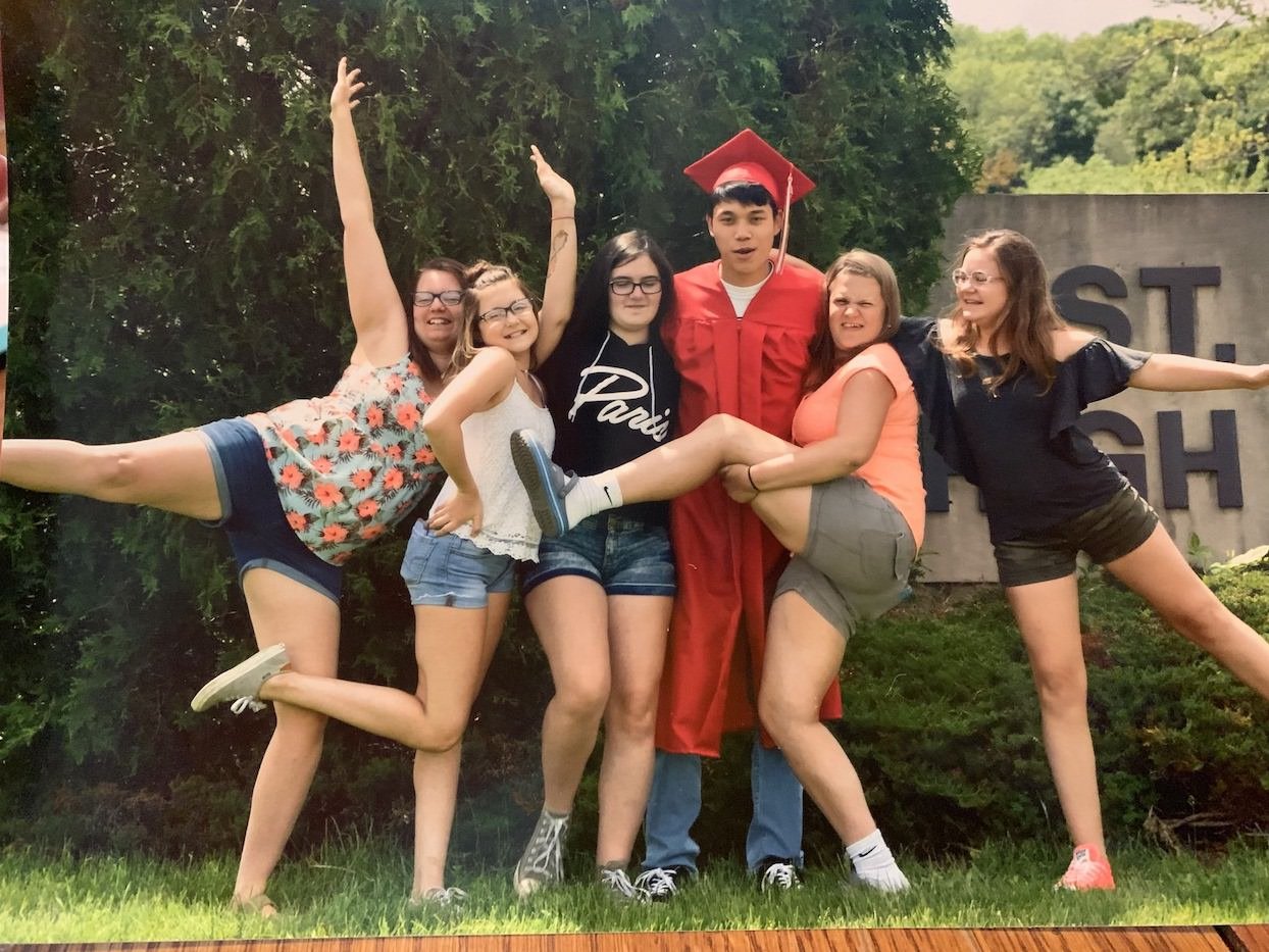 Thai student in graduation cap and gown with five girls