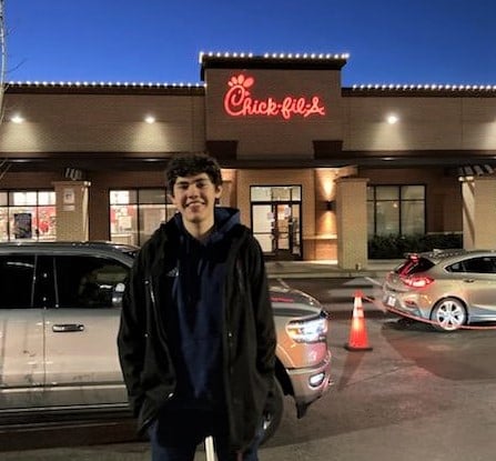 Thomas smiling in front of Chik-fil-A