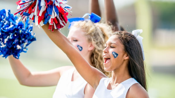 Two cheerleaders cheering with pom poms