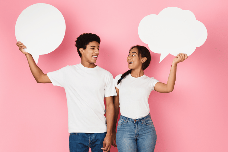 Two teenagers looking at each other and holding speech bubbles in their hands