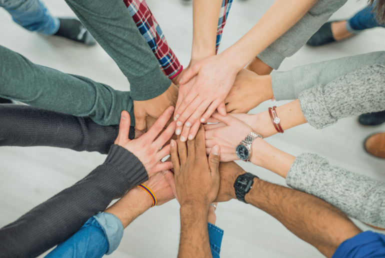 Community putting their hands together in support