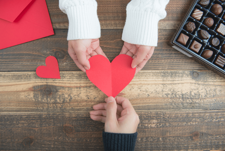 hands giving paper heart