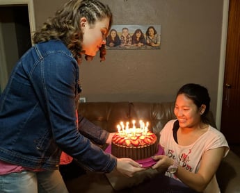 girl holding birthday cake for exchange student