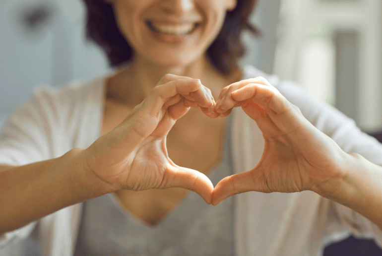 woman holding her hands together in a heart shape