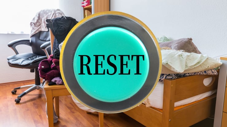 a reset button with a messy room in the background