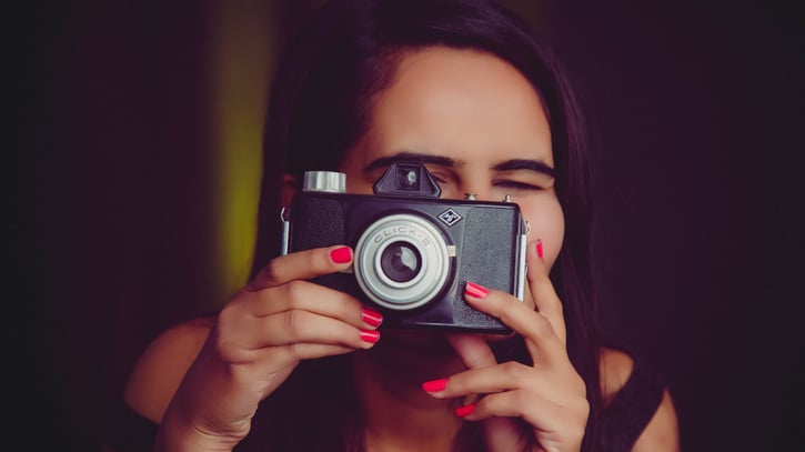 a young woman taking photos with a manual camera