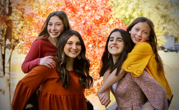younger girls piggy back on older girls with fall decor