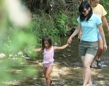 big sister and little sister holding hands and walking in nature