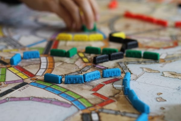 plastic train car tokens linked across a Ticket to Ride game board