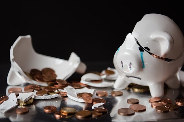 broken piggy bank with scattered change