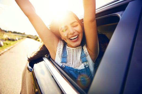 happy girl with arms out car window