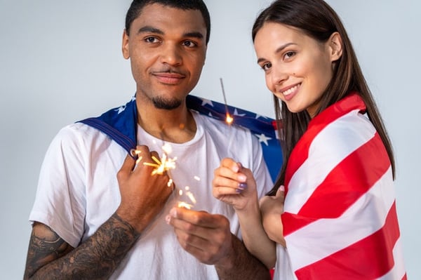 couple wrapped in american flag holding sparklers