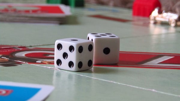 two dice on the middle of a Monopoly game board