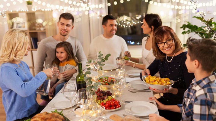 family eating meal together with fresh veggies and wine