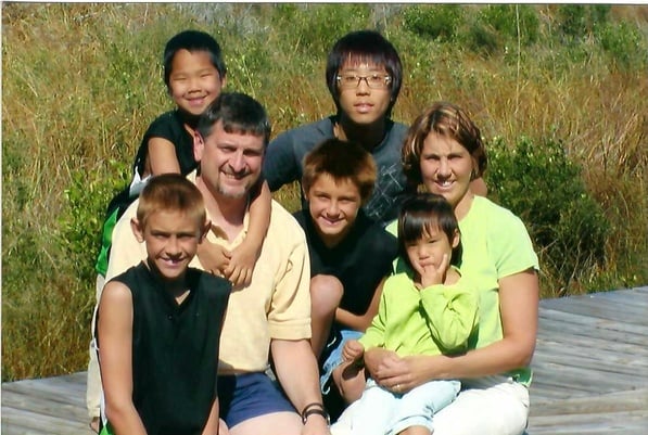 family photo of parents and four children with exchange student from Korea