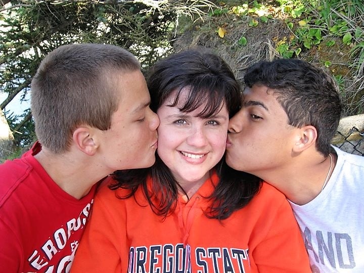 mom with sons kissing each cheek