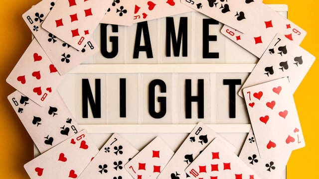 game night sign with playing cards around it