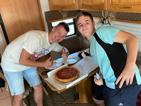 boys smiling with deep dish pizza