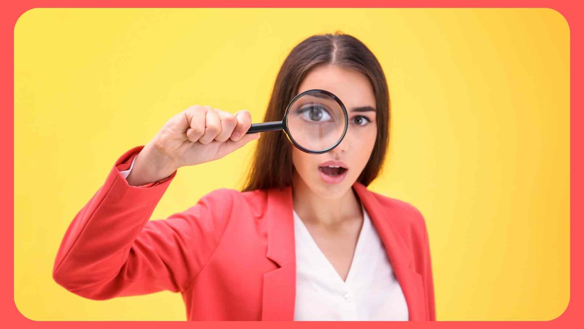 girl looking through magnifying glass surprised