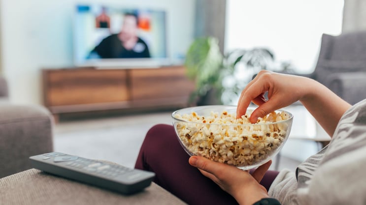 girl watching tv with popcorn