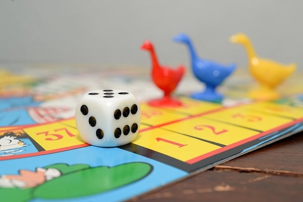 colored goose tokens and a die on a game board