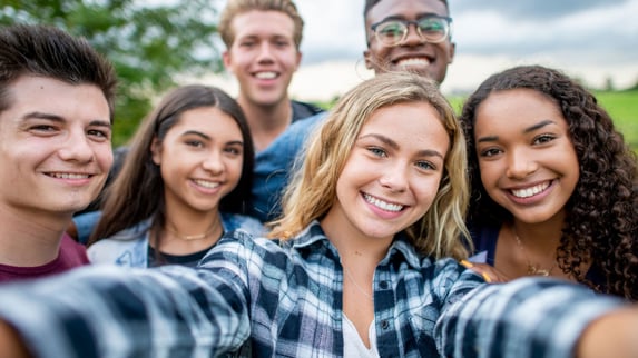 group of smiling teens taking a selfie