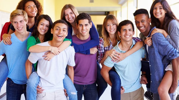 group of teenagers standing together smiling