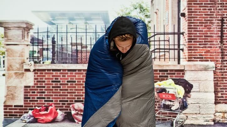 homeless person with sleeping bag