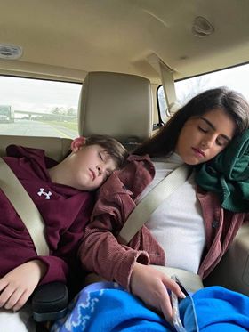 A Spanish exchange student and her host brother sleeping in the car