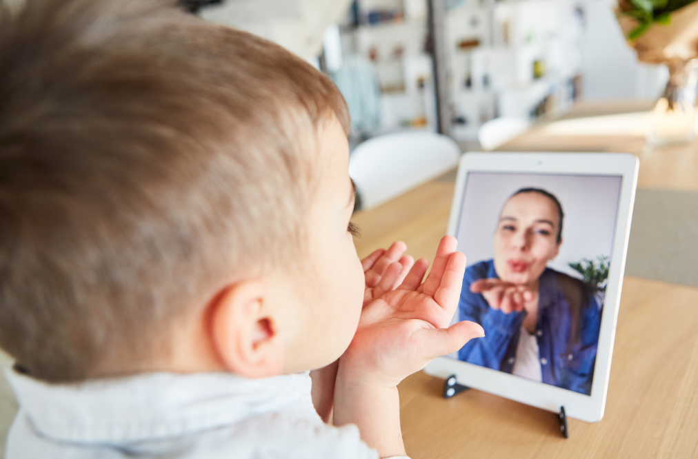 child blowing kiss to sister on Zoom