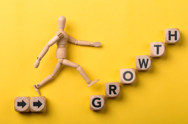 wooden man walking toward growth