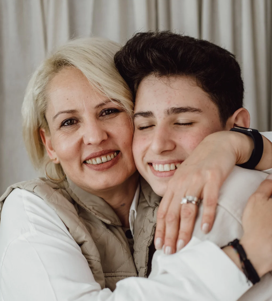 older woman hugging teen boy