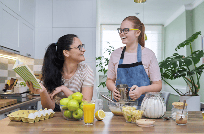 Mom and teen cooking and smiling