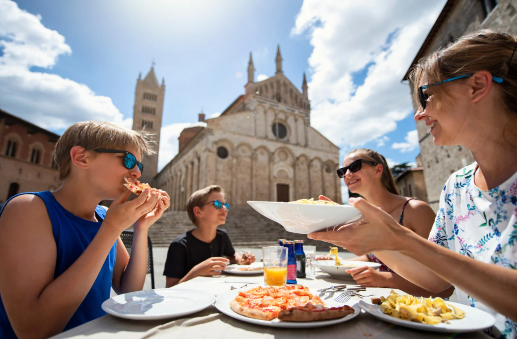 family eating pizza and pasta outdoors