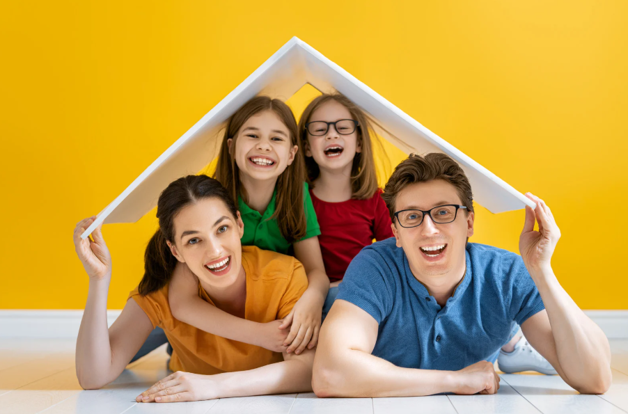 family holding cardboard roof over head