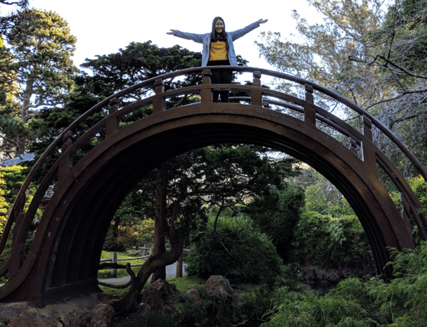 girl on arched bridge in botanical garden