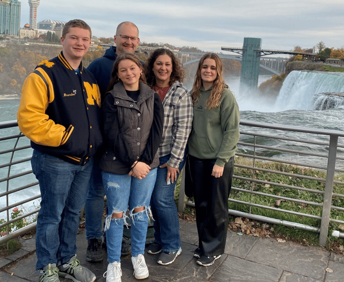 family standing in front of waterfall