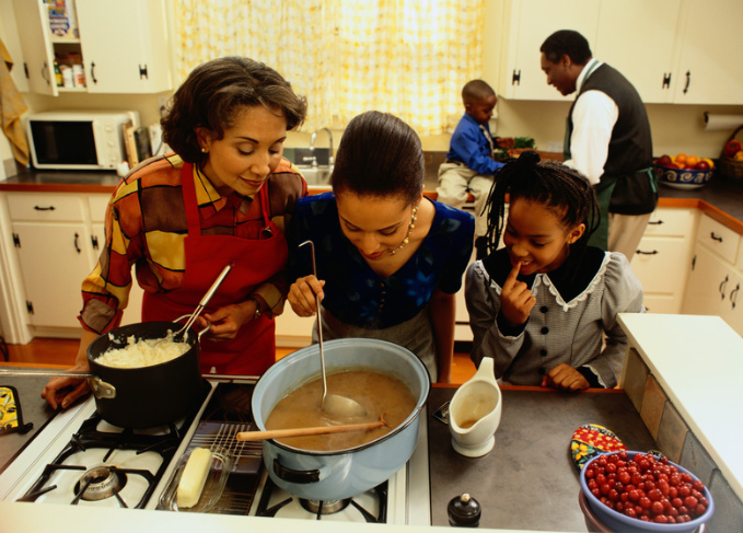 mom and girls cooking potatoes and gravy