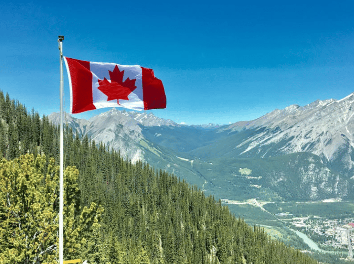 Canadian flag flying over mountains