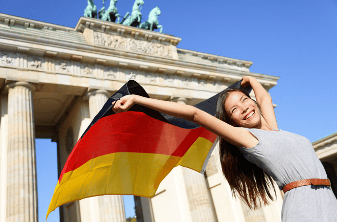 girl with German flag in front of Brandenburg Gate