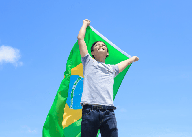smiling boy holding Brazilian flag